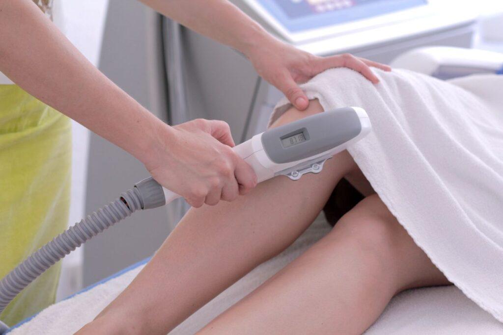 Beinbehandlung mit Laserhaarentfernung im Kosmetikstudio, professionelle Methode zum haare entfernen mit Geraet